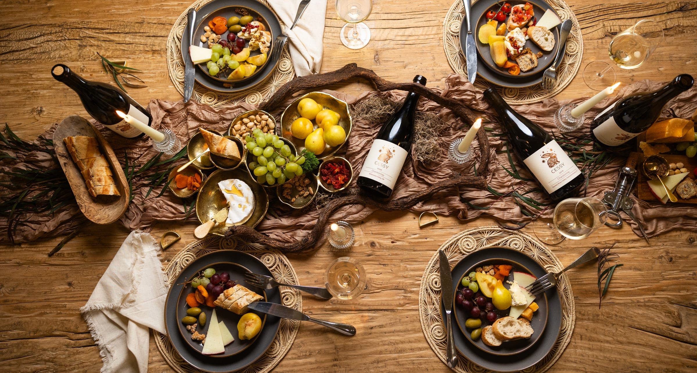 Cessy wines on a candlelit table with artisanal cheese and fresh fruit