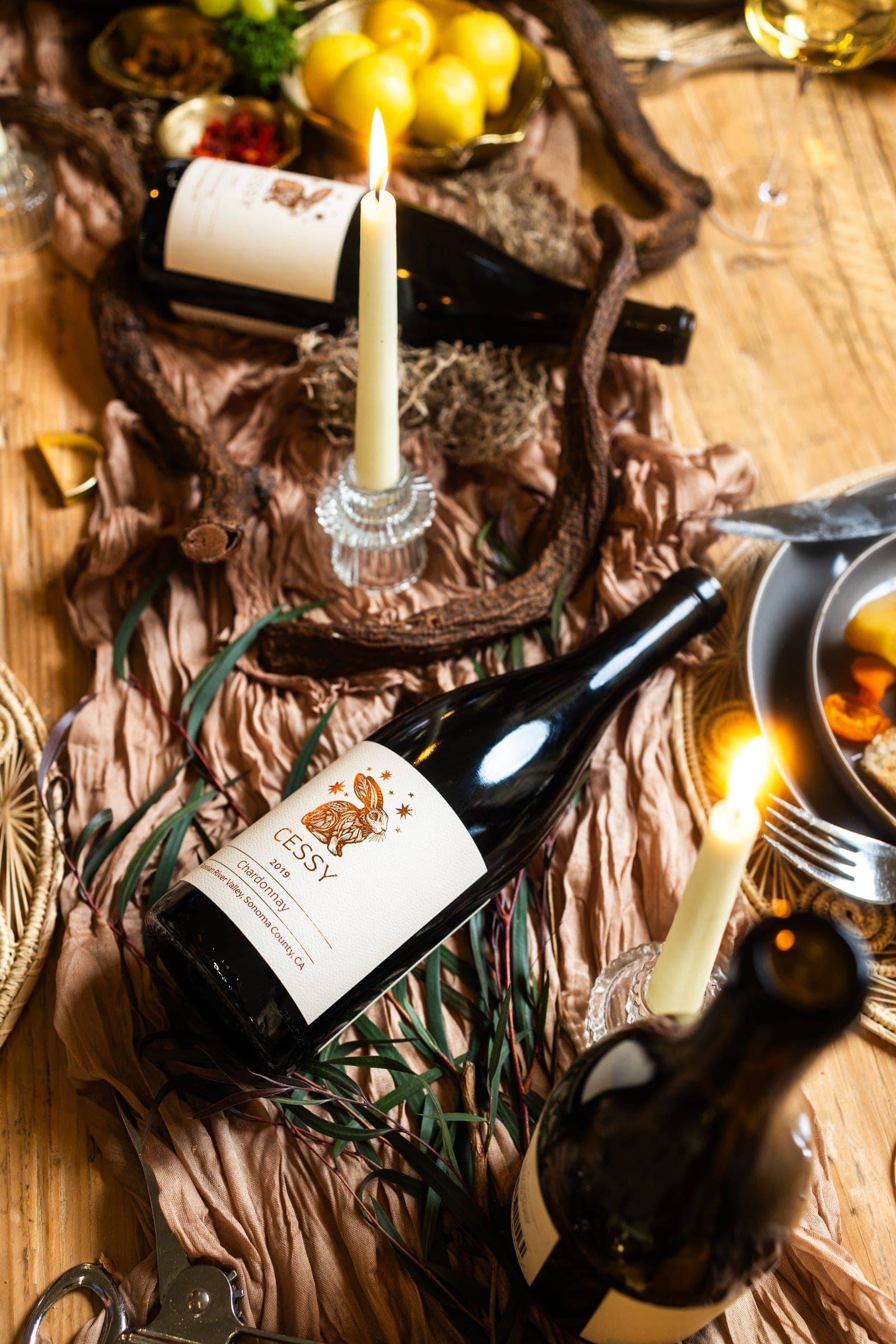 Cessy wine bottles with candles on a table